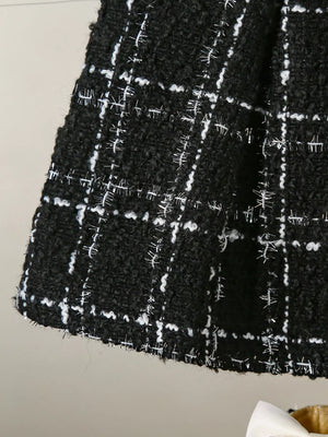 Black and white plaid baby skirt with textured fabric and metallic threads.