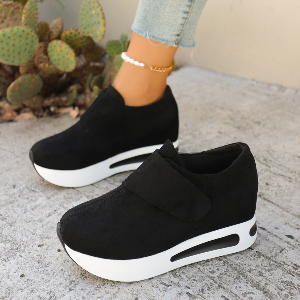 Black chunky platform sneakers with air cushion sole and hook-and-loop strap.