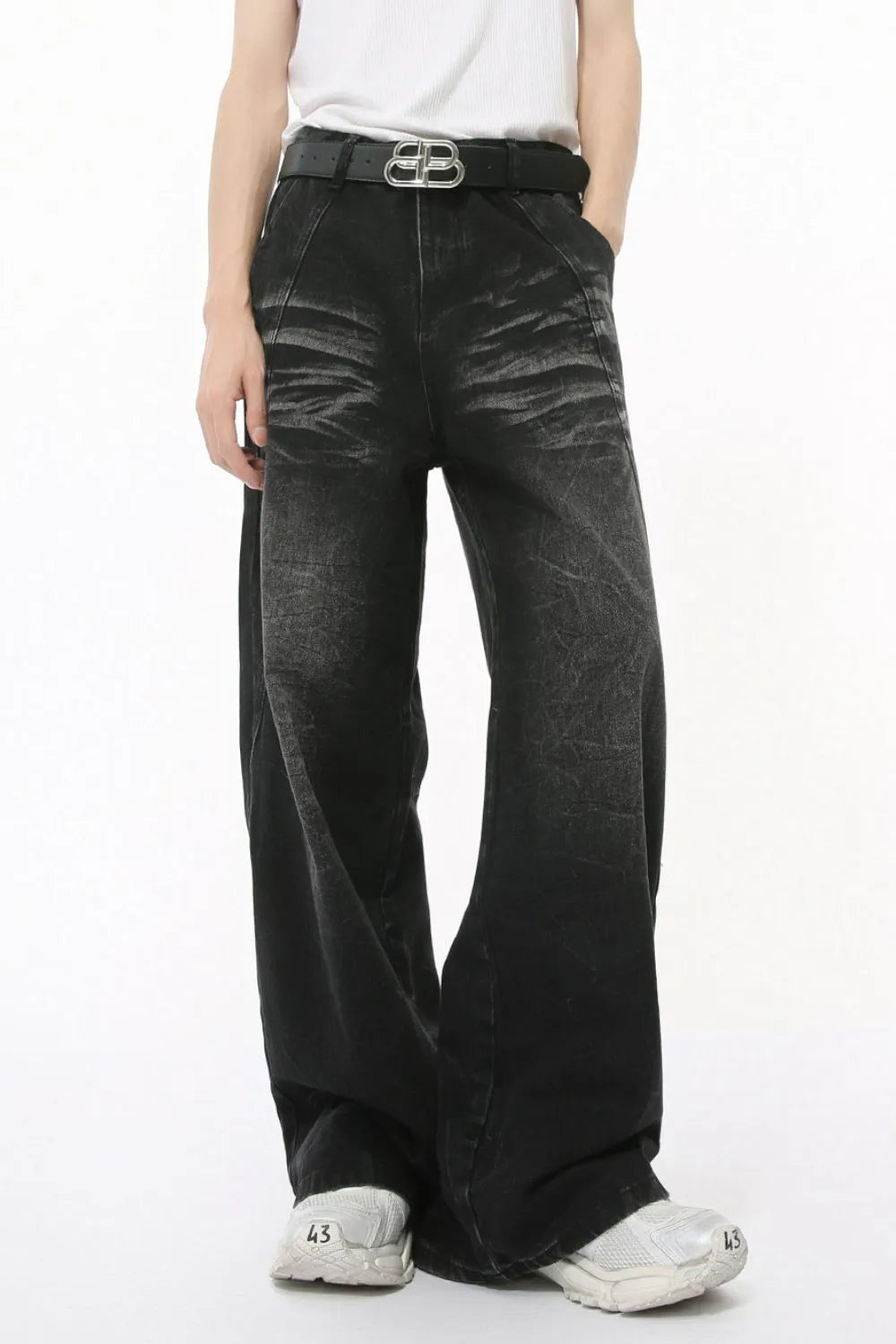 Faded black denim palazzo trousers with a wide leg and high waist, styled with a belt.