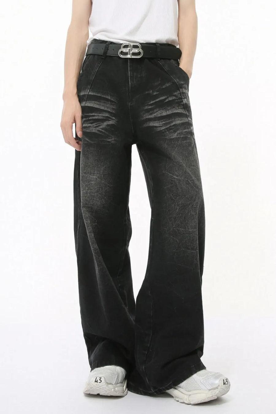 Faded black denim palazzo trousers with a wide leg and high waist, styled with a belt.