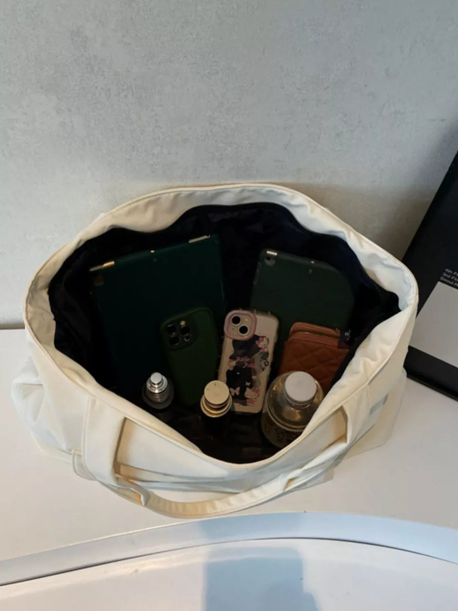 Spacious cream nylon shoulder bag with flap open, showing contents like tablets, phones, and bottles.