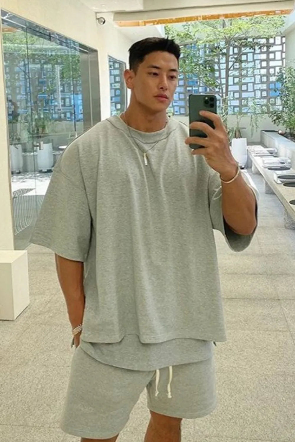 Oversized gray drop-shoulder tee with short sleeves and a crew neck.
