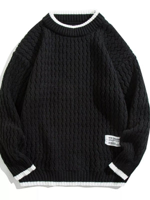 Black textured knit sweater with white trim on collar and cuffs.