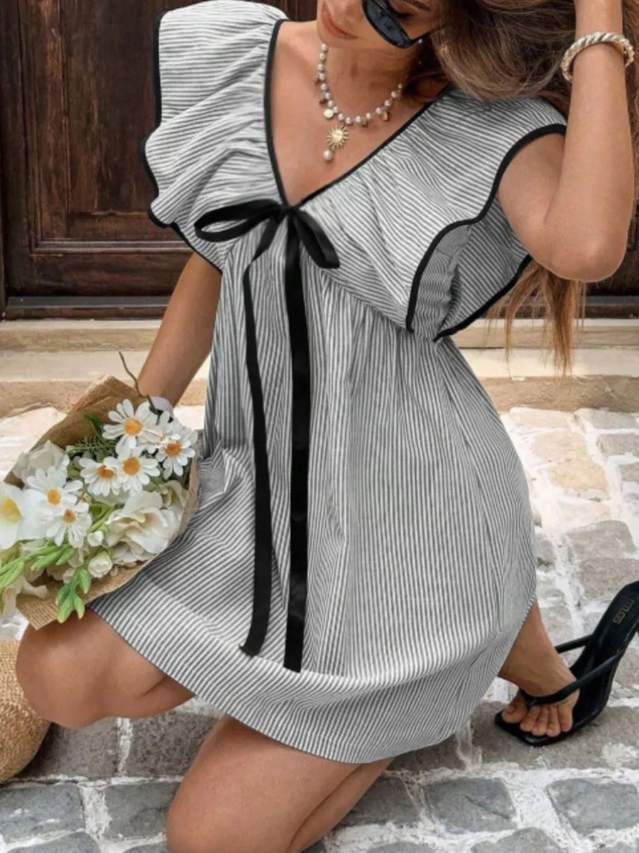 Striped mini dress with ruffled sleeves, black trim, and a black bow detail.