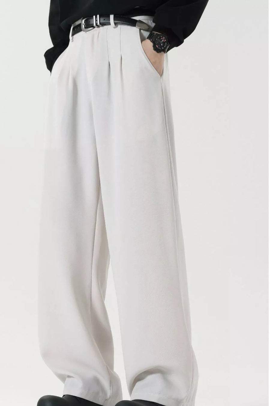 Men's white wide leg dress pants with pleats and a black belt.