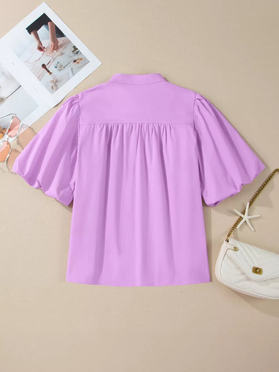 Lilac cotton shirt with notched collar, gathered yoke, and puff sleeves.