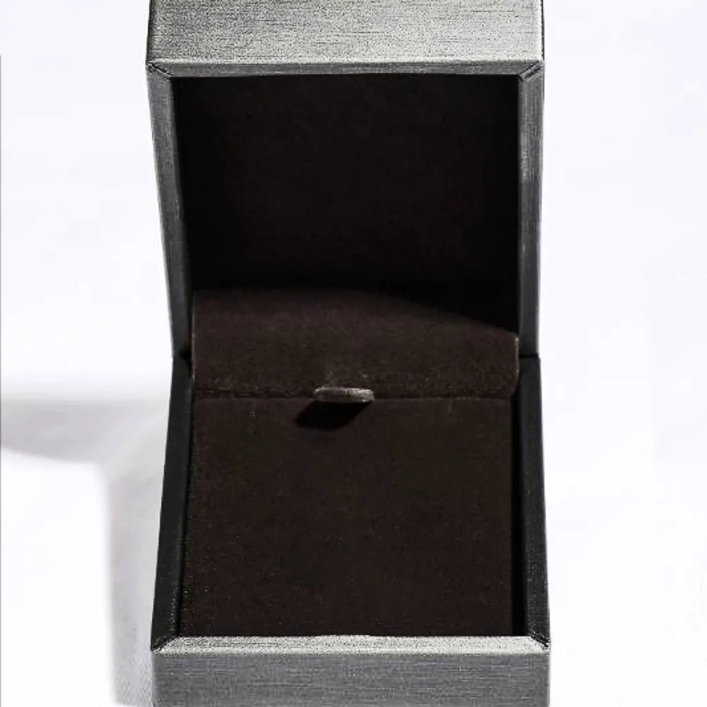 Empty jewelry box with dark velvet lining and clasp.