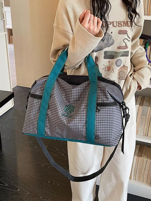 Large plaid travel bag with turquoise straps and a crossbody strap.