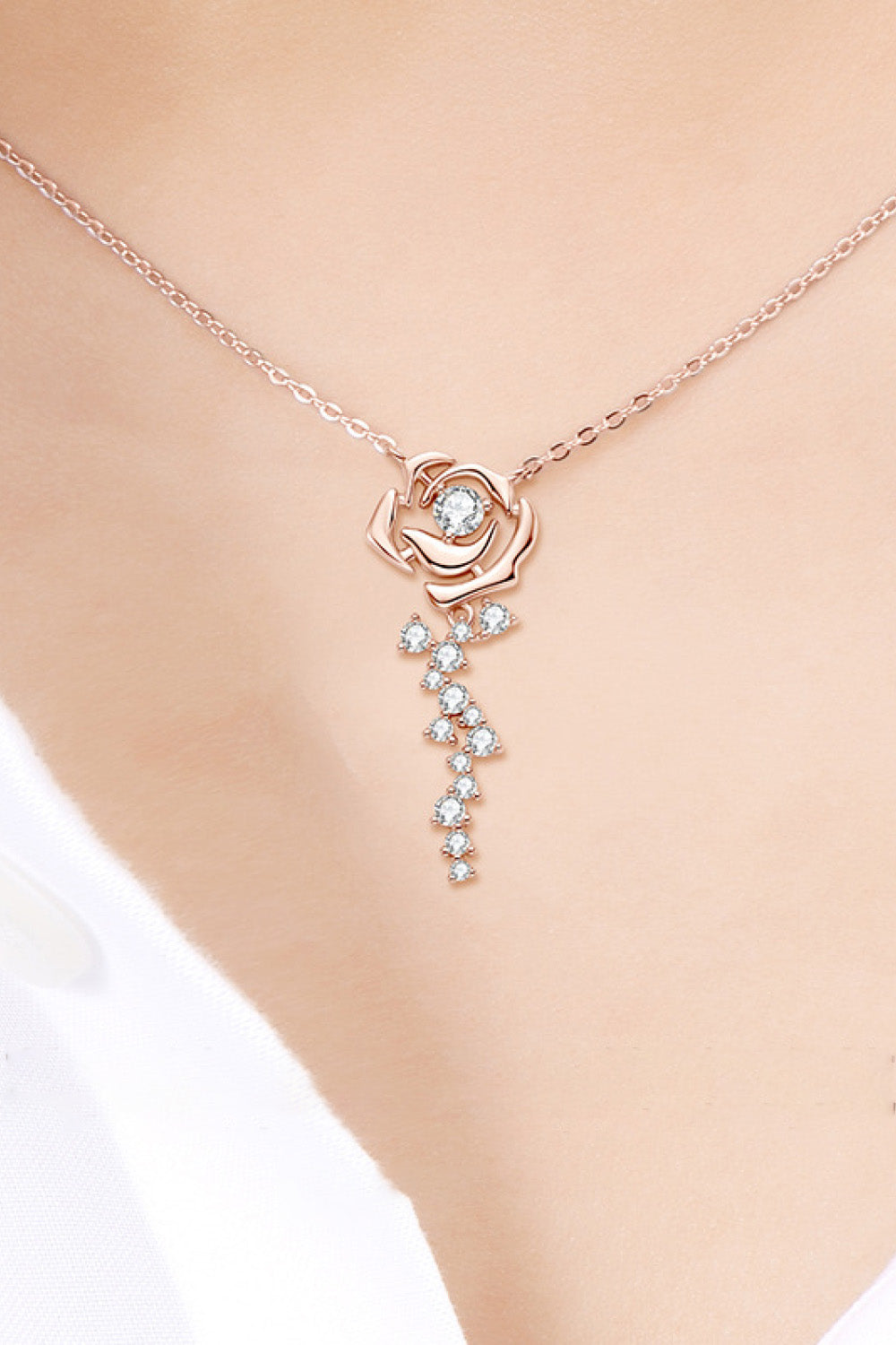 Rose gold necklace with rose pendant and cubic zirconia cascade detail.