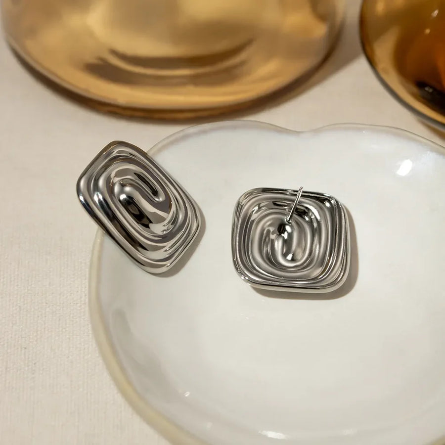 Sculpted swirl square earrings in silver with a contemporary, chic design.