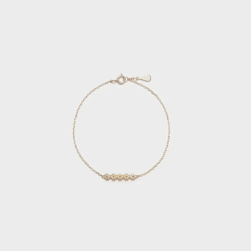 Silver chain bracelet with five delicate daisy charms.