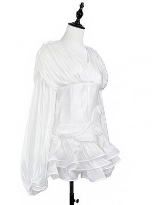 White cotton mini dress with corset waist, ruffled skirt, and voluminous sleeves.