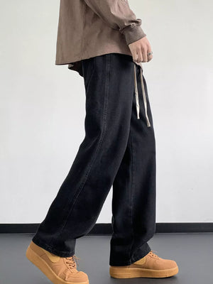 Black oversized drawstring jeans with a loose fit and a visible drawstring waist.