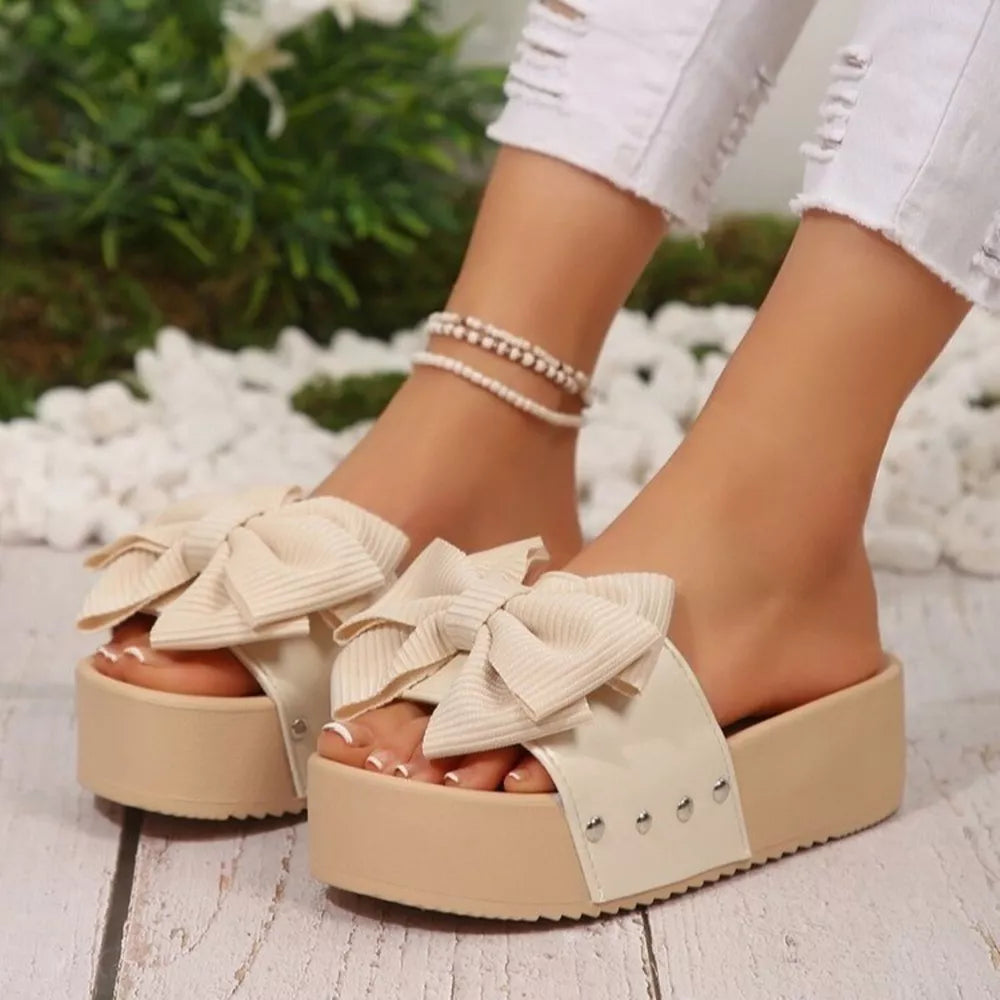Ribbed bow accent platform sandals in white with chunky sole and stud detail.