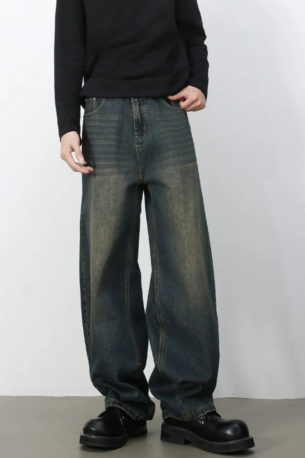 Faded baggy denim jeans in a distressed light blue wash with a relaxed fit.