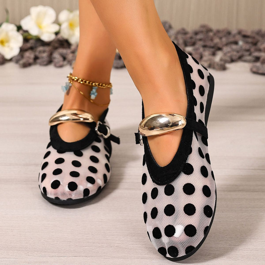 Black polka dot mesh slip-on flats with gold buckle detail and ankle bracelet.