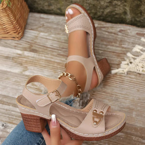 Khaki laser-cut detail block heel sandals with gold buckle and chain accent.