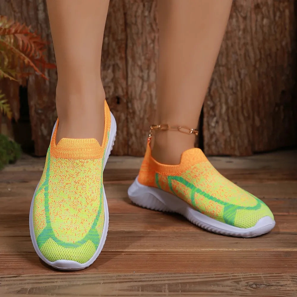 Geometric knit slip-on trainers in yellow and orange with green accents.