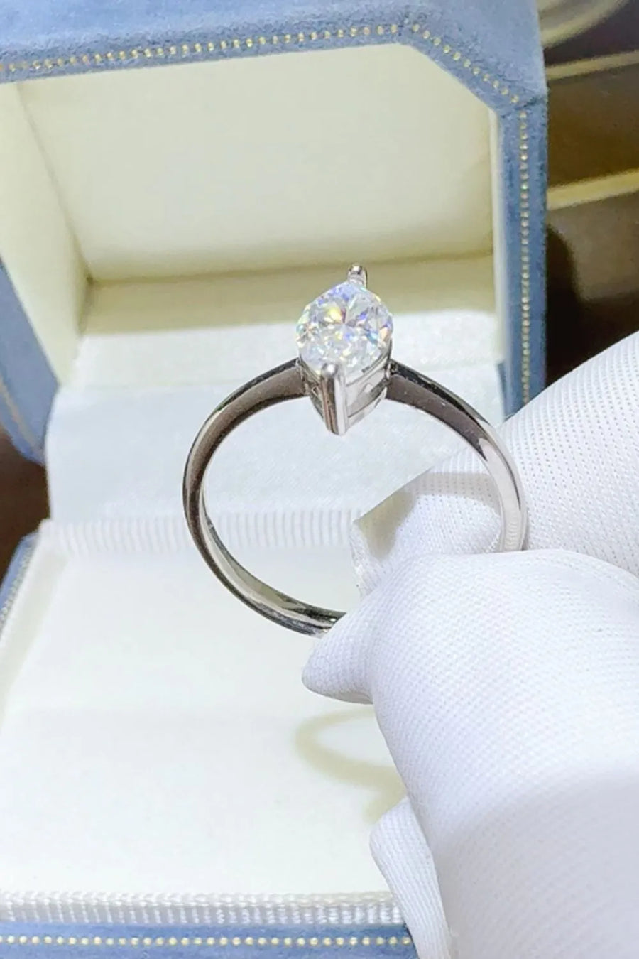 Sterling silver ring with a marquise cut solitaire diamond in a white gold setting.