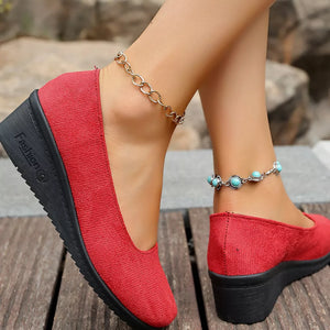 Red textured round toe wedge slip-ons with black wedge sole.