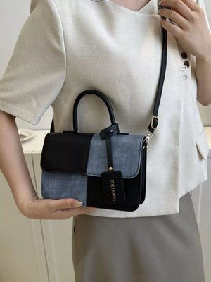 Chic two-tone PU leather crossbody bag with black and denim blue panels and a black tag.