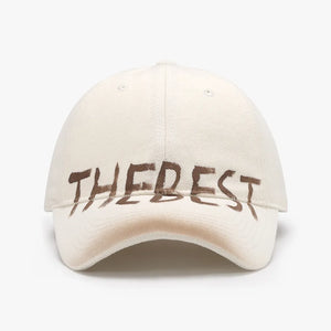 Textured denim baseball cap in beige with brown graphic text detail