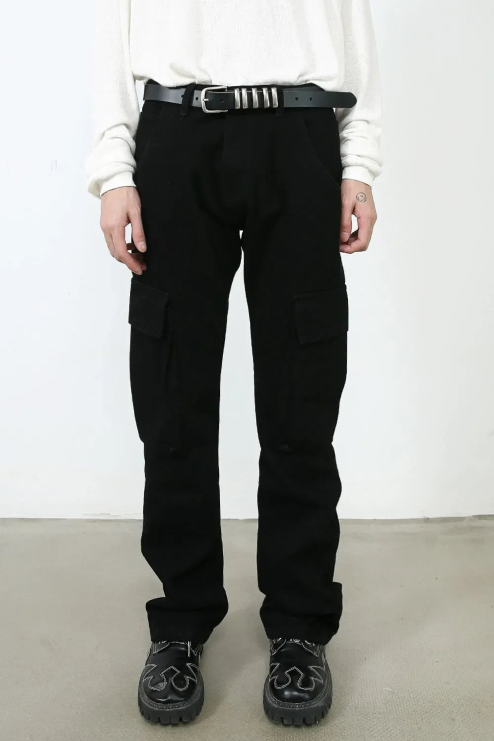 Black denim utility trousers with cargo pockets and a relaxed fit.