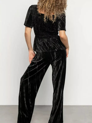 Black velvet two-piece set with flutter sleeves and wide-leg pants.