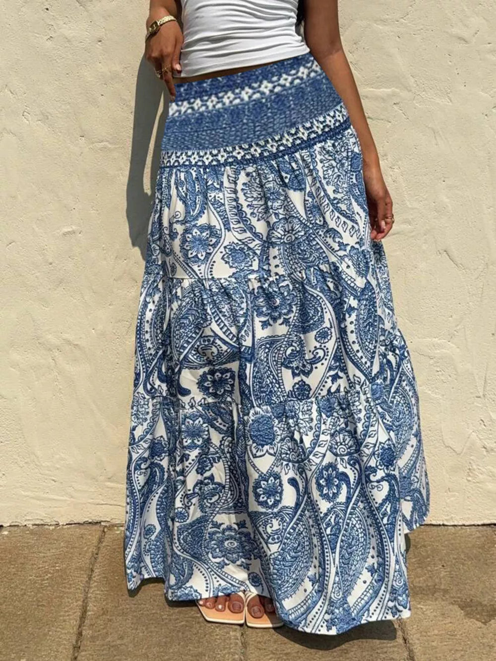 Maxi skirt with blue and white paisley print, tiered design, and smocked waistband.