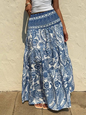 Maxi skirt with blue and white paisley print, tiered design, and smocked waistband.
