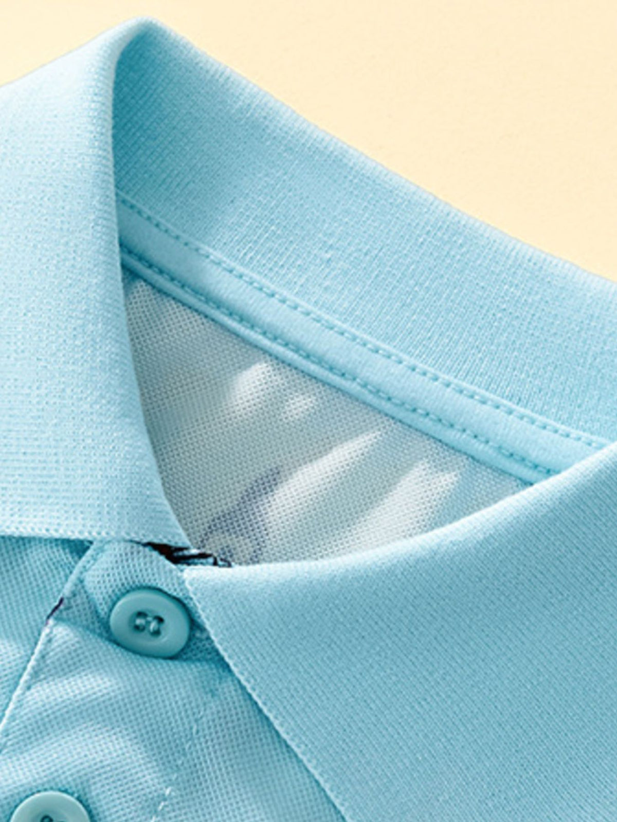 Light blue toddler polo shirt with cartoon print detail and button closure.