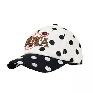 Baseball cap with white and black polka dots, embroidered text and red accent.