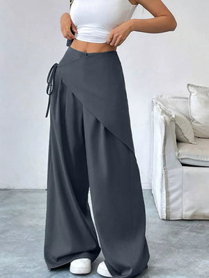 Dark gray wide-leg wrap pants with a tie waist and flowy silhouette