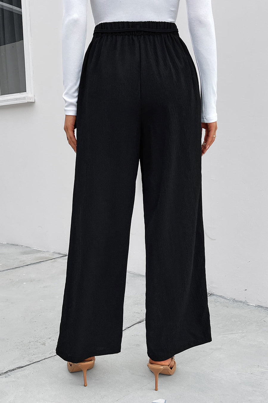 Black high-waist tie palazzo trousers with a relaxed fit and wide leg.