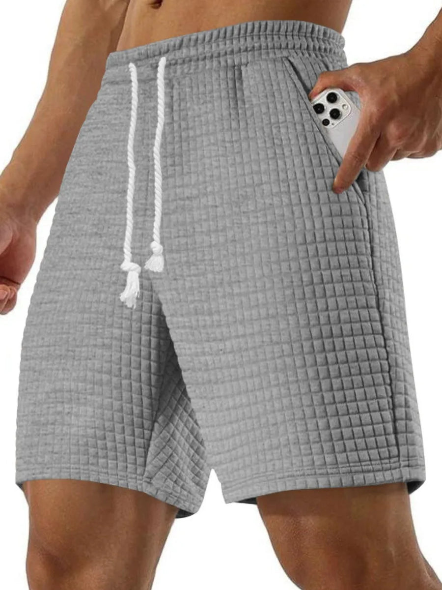 Gray waffle knit relaxed fit shorts with drawstring and pocket detail.