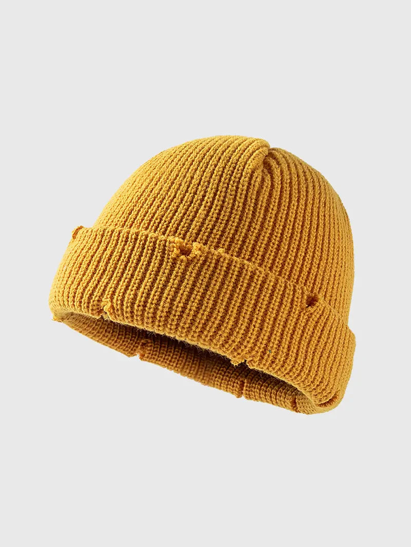 Yellow ribbed knit beanie with distressed details and a cuffed brim.