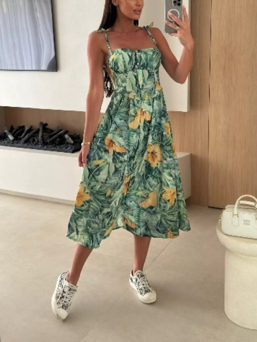 Floral tie-strap midi dress in Matcha Green with yellow flowers, A-line cut, and tie straps.