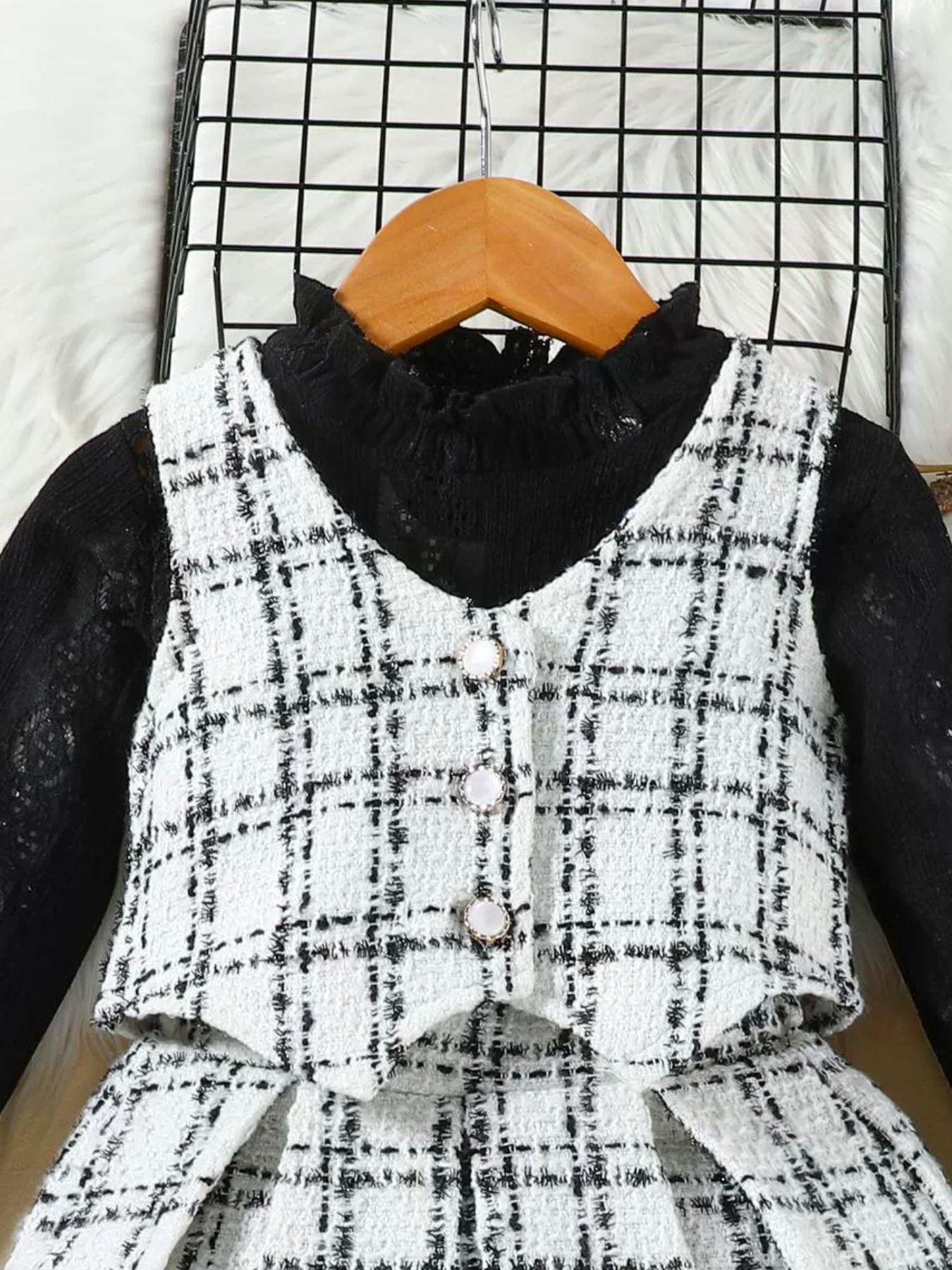 Toddler black and white plaid vest set with decorative buttons over a black lace top.