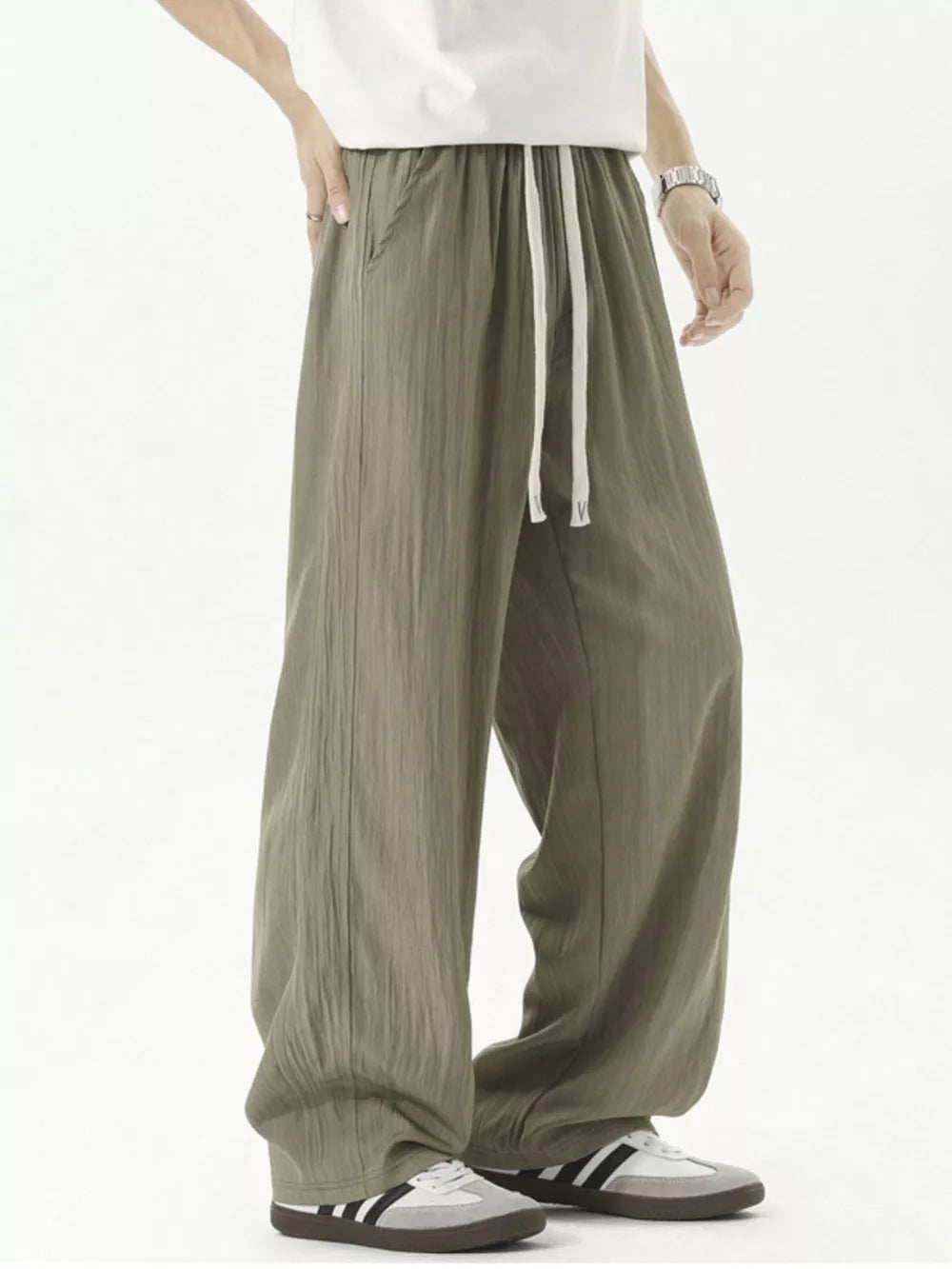 Men's green track pants with drawstring waist and textured fabric.