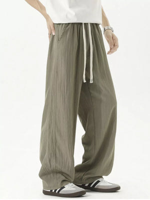 Men's green track pants with drawstring waist and textured fabric.