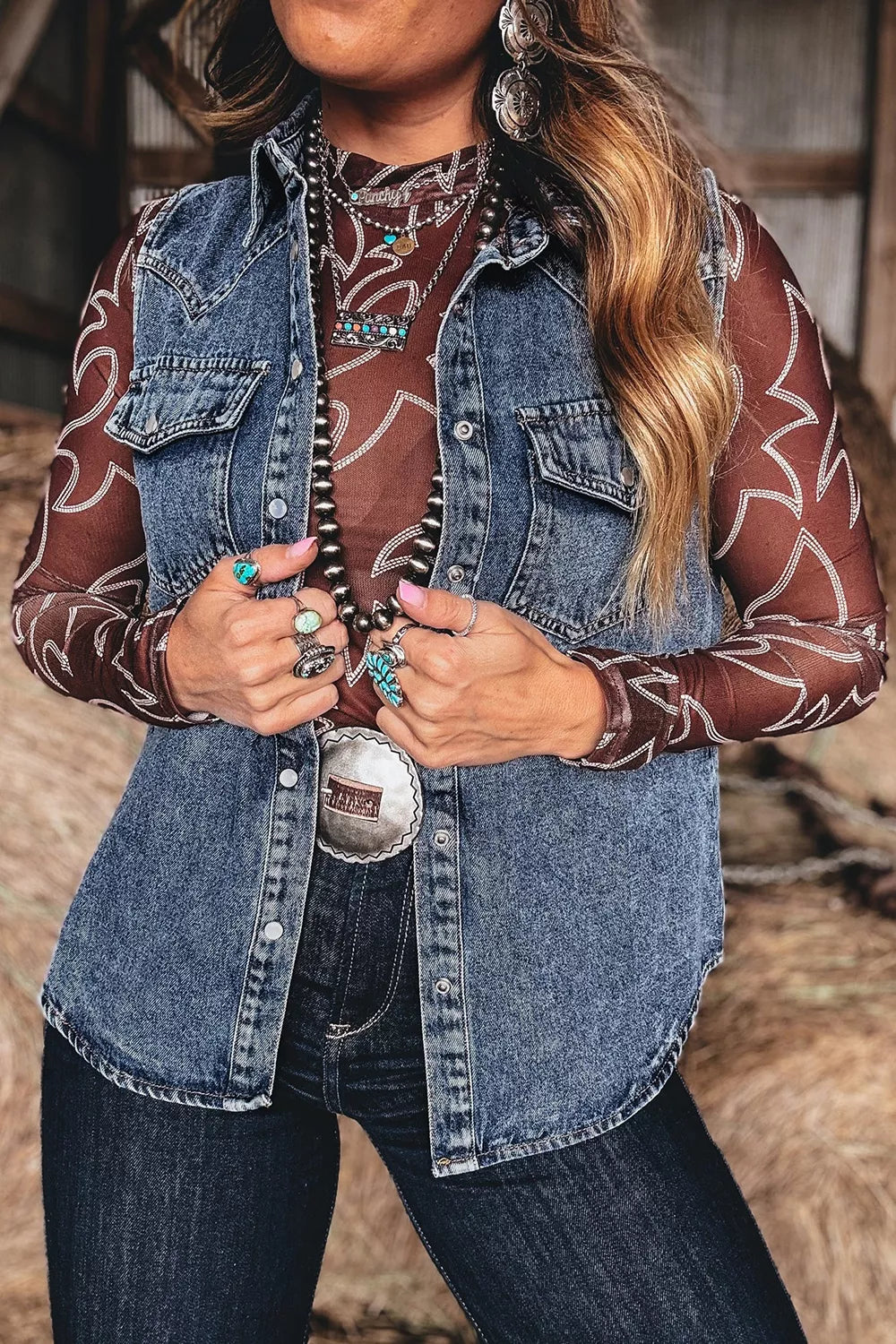 Blue denim button-front sleeveless vest with chest pockets.