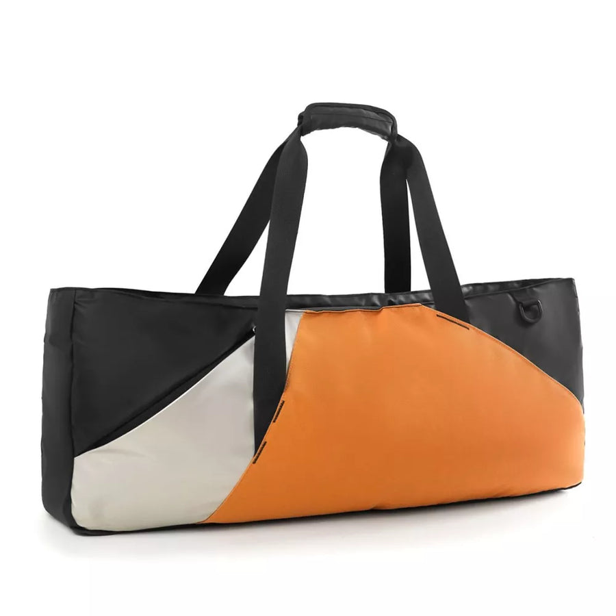 Modern color block travel bag in orange, black, and white with dual handles and a zip closure.