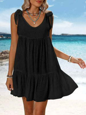 Black cotton tie strap mini dress with tiered ruffle hem and scoop neck.