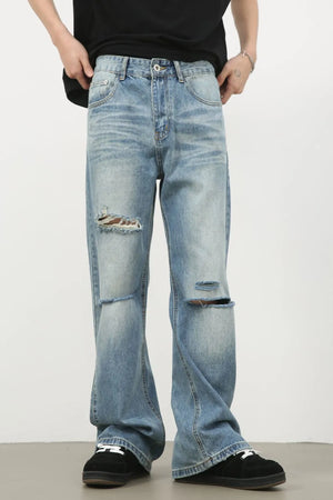 Distressed flare-leg denim jeans in medium wash with ripped details.