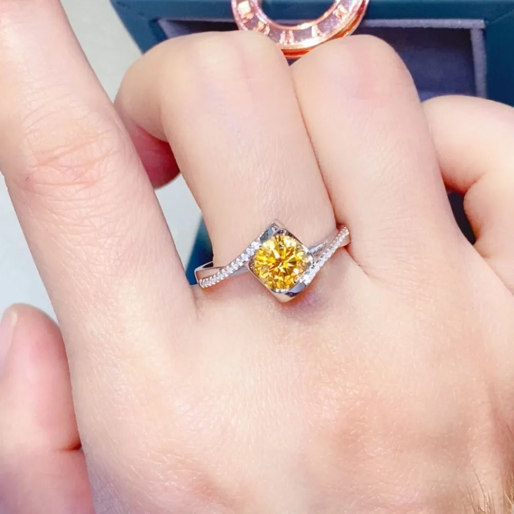 Radiant yellow moissanite twist ring in silver with diamond accents.