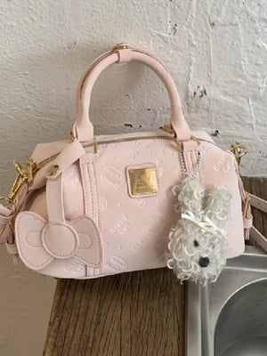Blush pink crossbody bag with bow detail and fluffy bunny charm