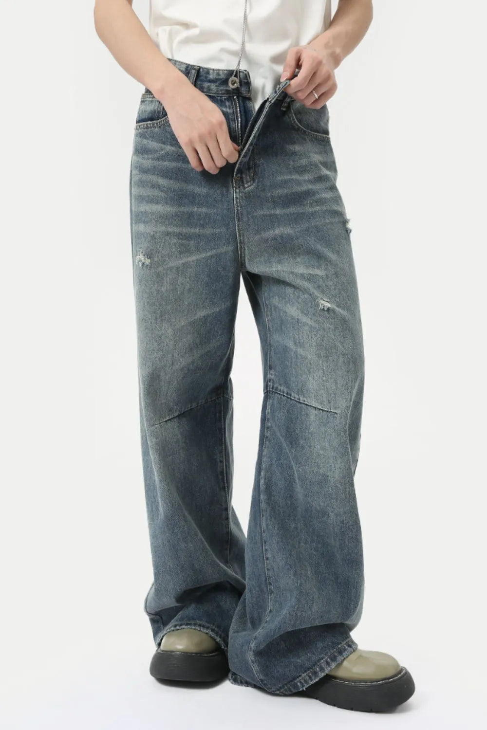 Oversized patchwork distressed denim trousers in medium wash with a wide leg and distressed details.