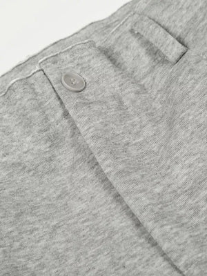 Men's gray sweatpants detail showing button closure and fabric texture.