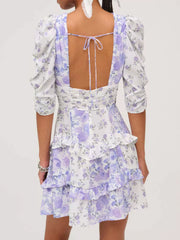 Ruched floral tie-front dress with puff sleeves and tiered ruffled skirt in purple and white.