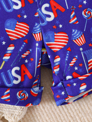 Baby shorts with patriotic USA print, featuring American flags, cupcakes, and fireworks on blue fabric.